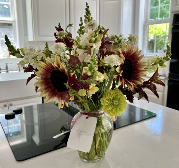 A summer bouquet arrangement with sunflowers, snapdragons, zinnias, and more.